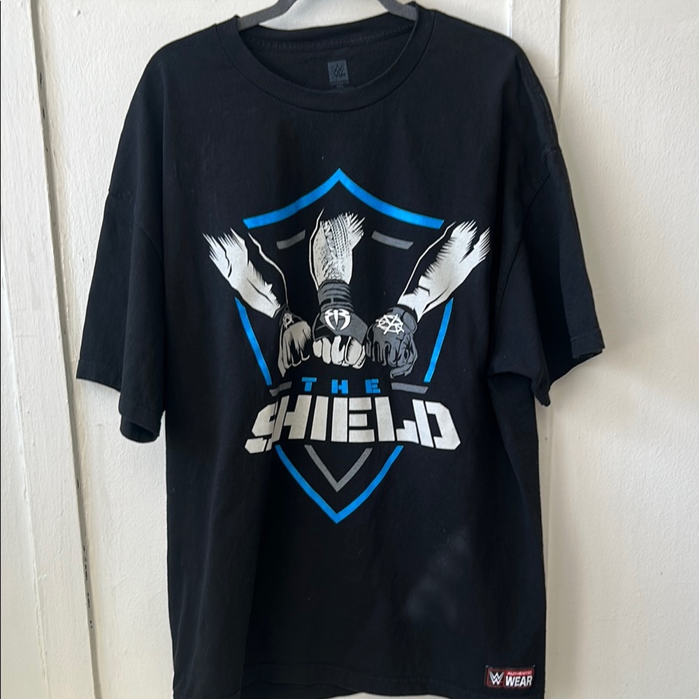 The SHIELD: Black graphic Tee with Front Fist hit and back SHIELD hit (WWE)